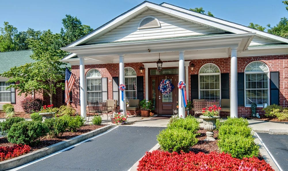 Front entrance of Riverview Terrace with flowers and flags