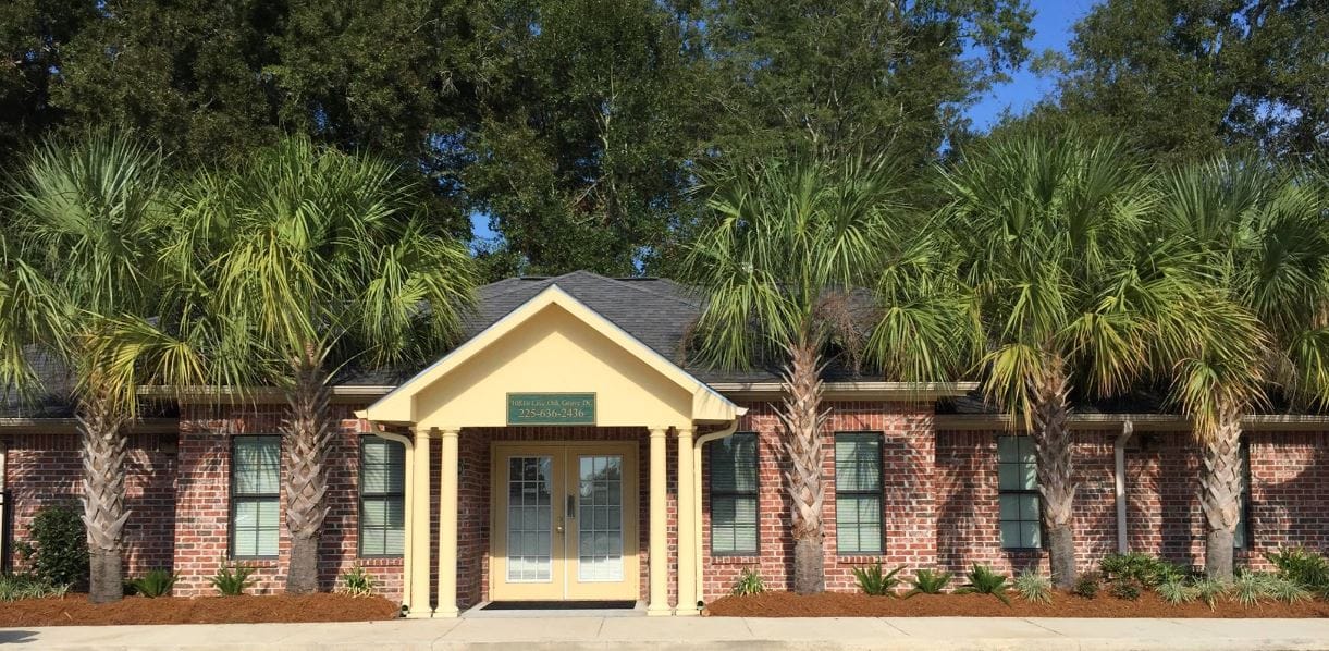Exterior view of a senior living facility with palm trees