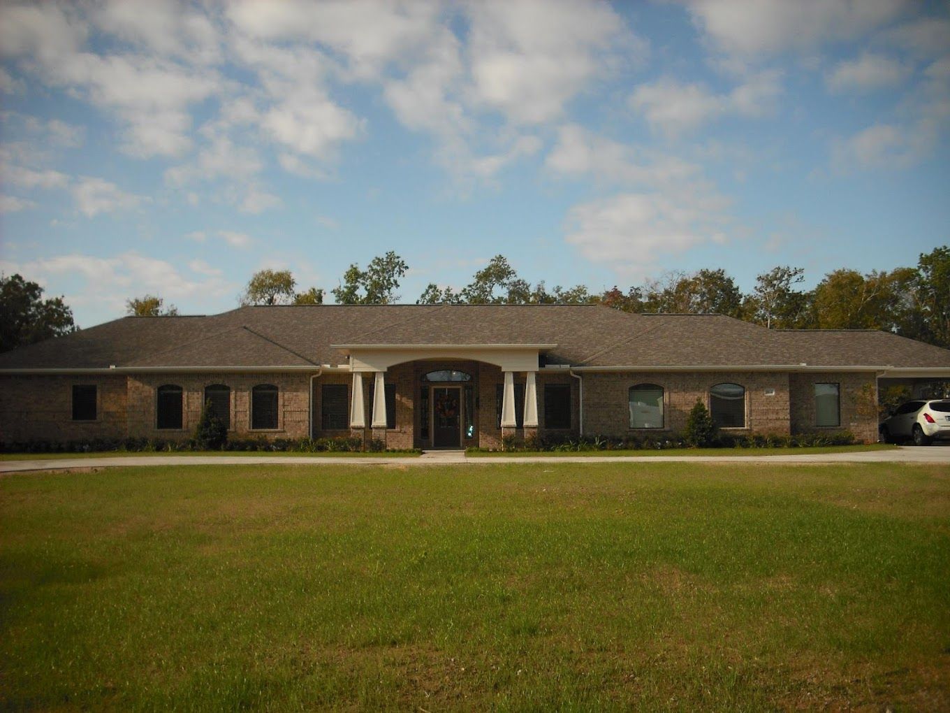 Exterior view of Serenity Gardens with lawn and trees