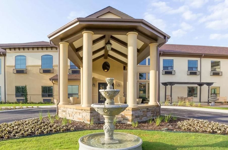 Exterior view of a senior living facility with fountain