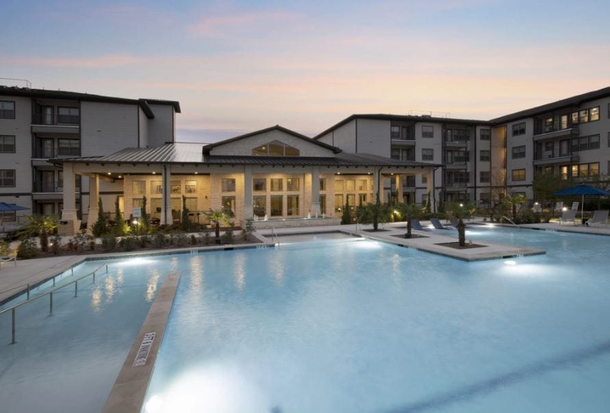 Outdoor pool area with facility building in the background