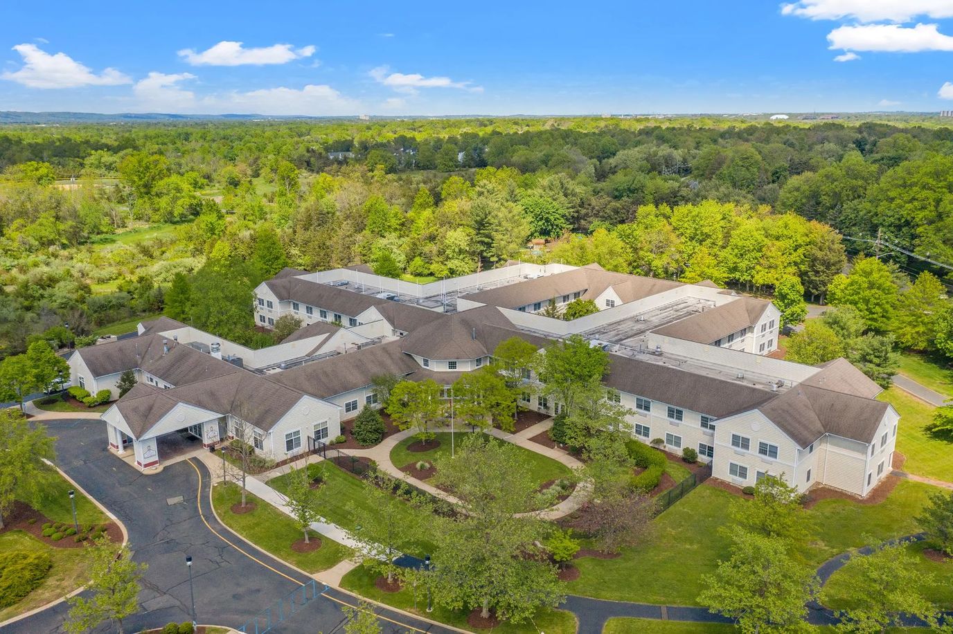 Aerial view of a senior living facility surrounded by greenery