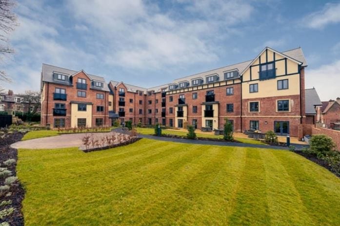 Exterior view of a senior living facility with landscaped gardens