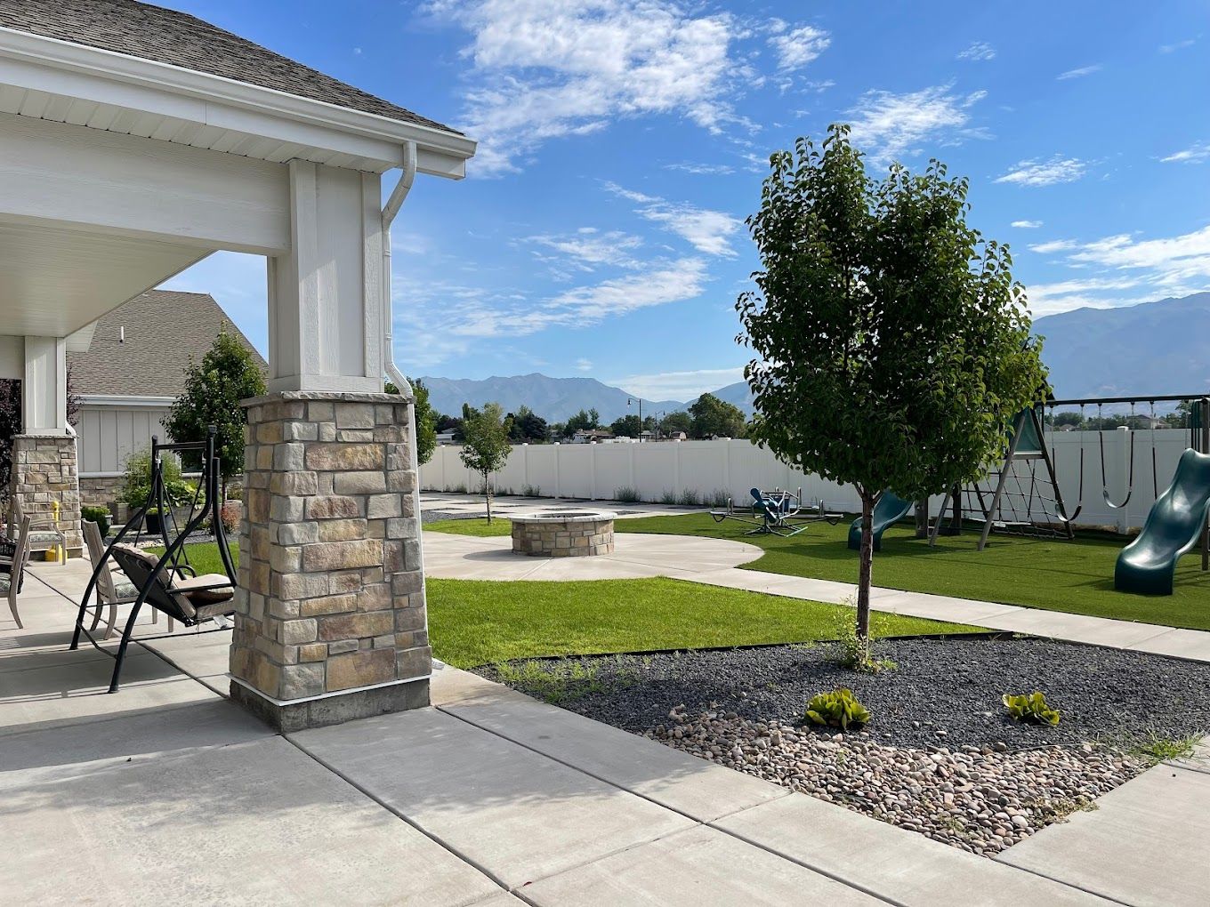 Outdoor area with lawn, trees, and playground equipment