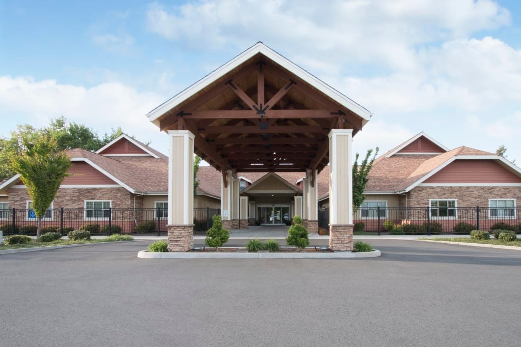 Exterior view of a senior living facility with a covered entrance