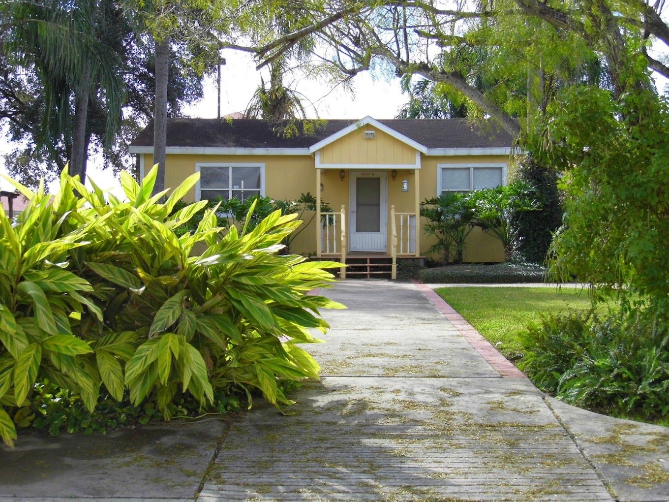 Exterior view of a yellow house with landscaping