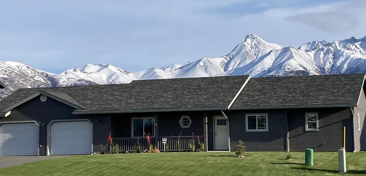 Exterior view of an assisted living facility with mountains in the background