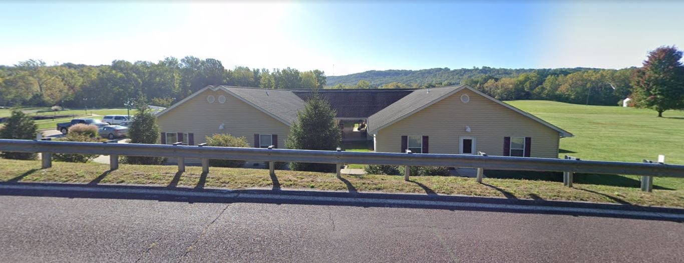 Exterior view of the facility surrounded by green landscape