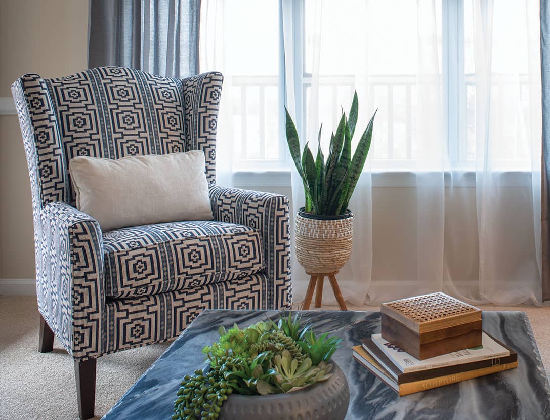 Cozy lounge area with patterned chair and plants