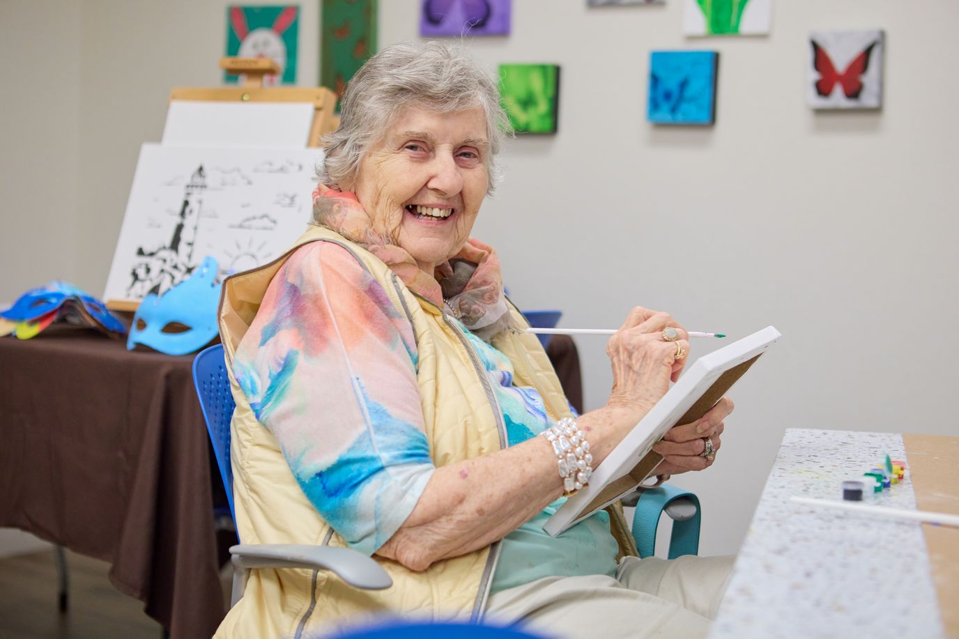 Resident painting in a bright activity room
