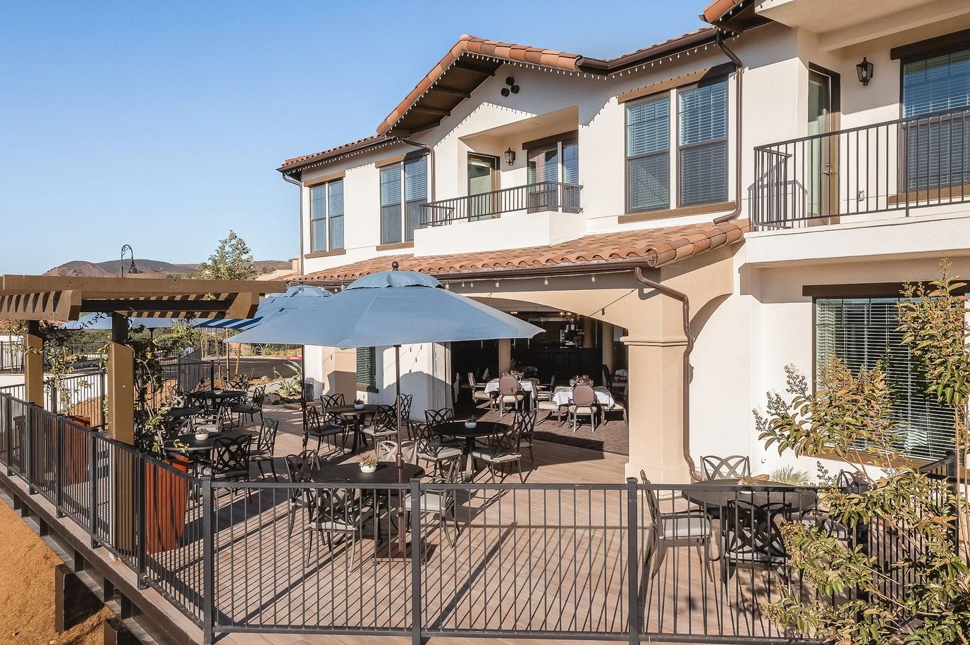 Outdoor seating area with restaurant-style tables and umbrellas