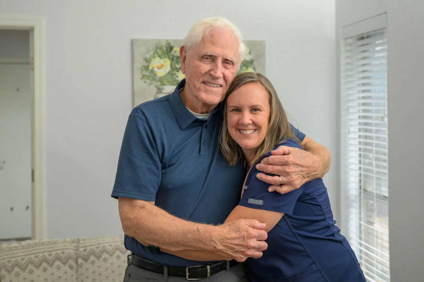 A resident and staff member sharing a warm hug