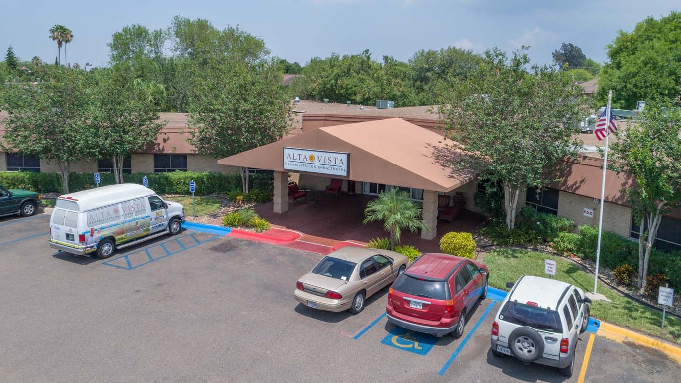Exterior view of Alta Vista facility entrance with vehicles