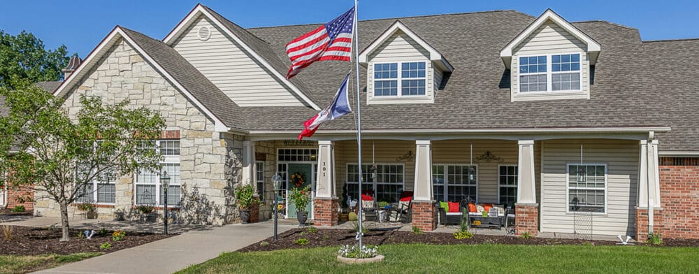 Beautiful exterior of Bickford of Marshalltown with American flags