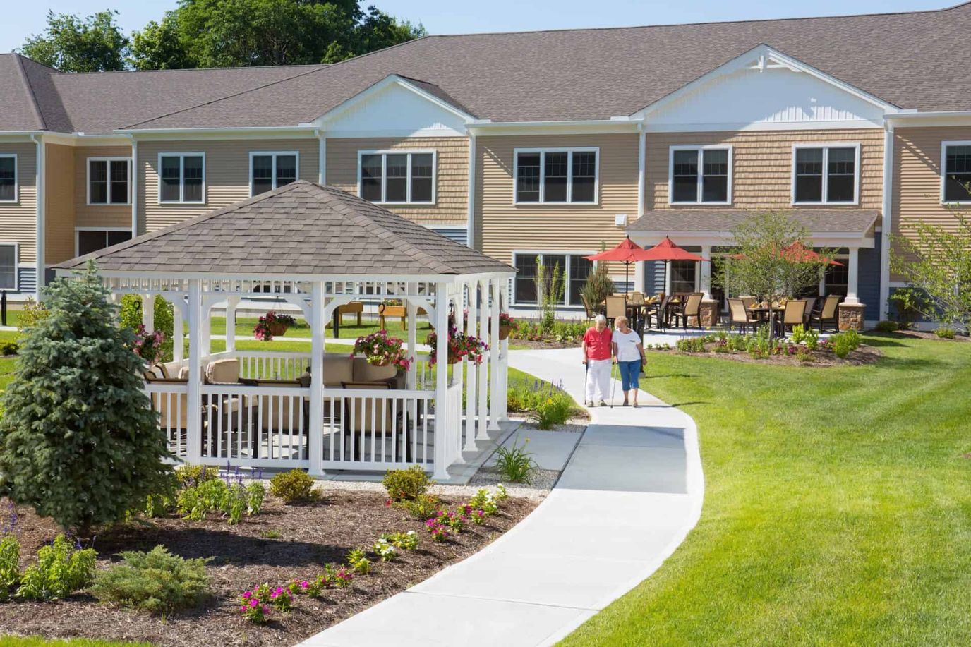 Two residents walking in a landscaped garden area