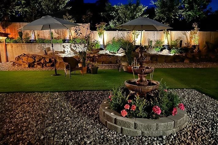Well-lit garden area with fountain and seating