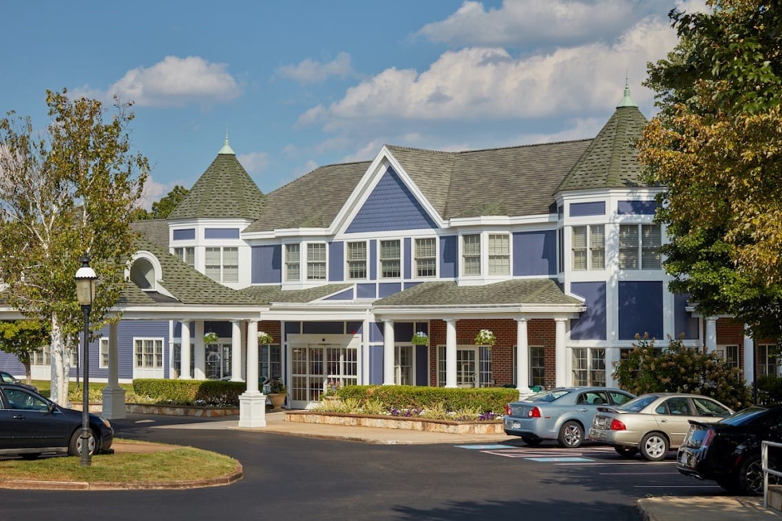 Exterior view of Heights Crossing Assisted Living facility with cars in the parking lot