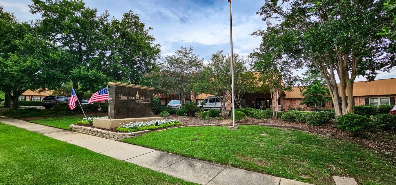 Exterior view of Heritage Manor with flags and landscaping