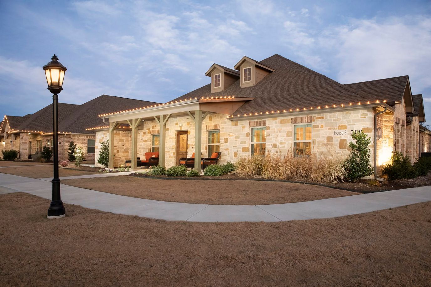 Exterior view of a senior living facility with a landscaped path