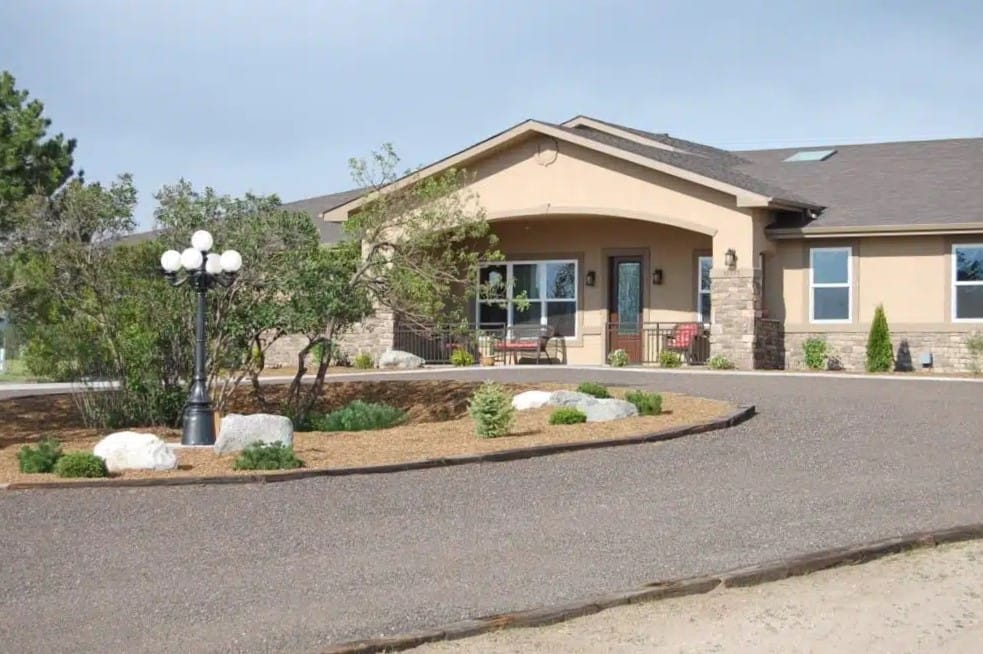 Exterior view of a senior living facility with gardens
