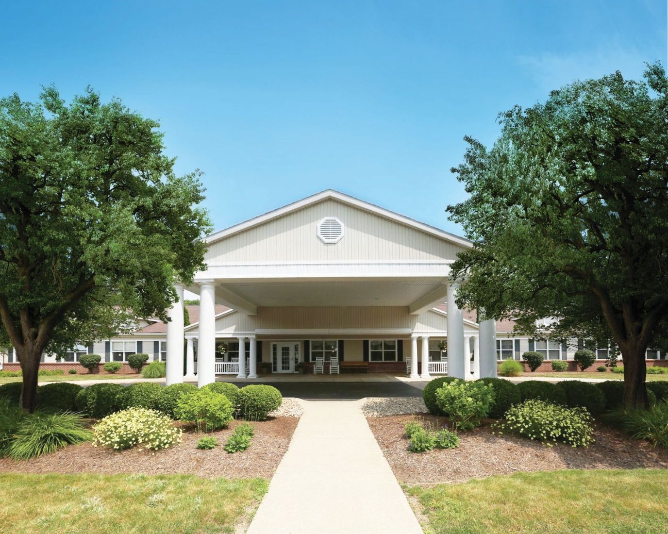 Exterior view of assisted living facility surrounded by gardens