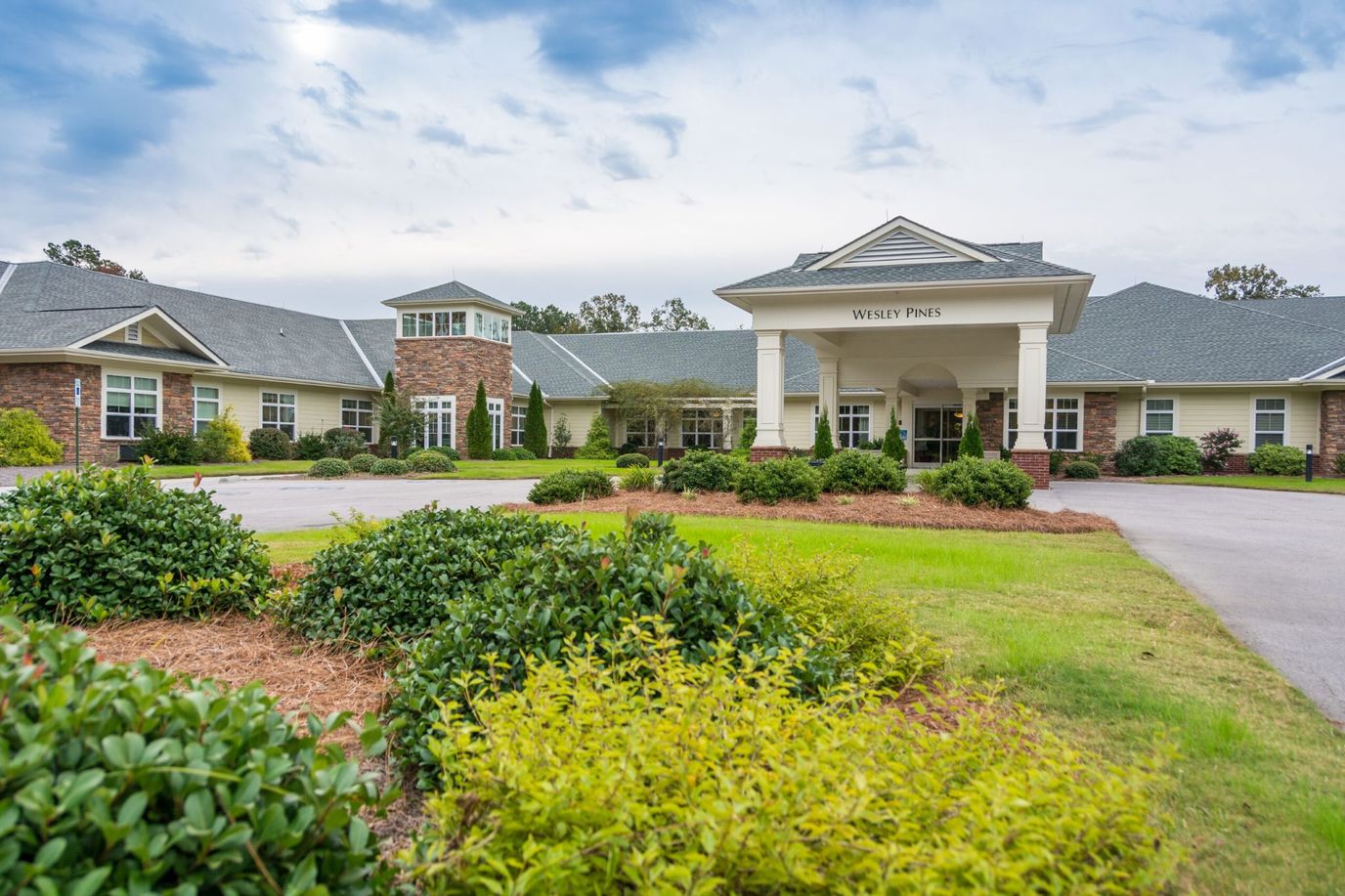 Exterior view of Wesley Pines facility with landscaped grounds