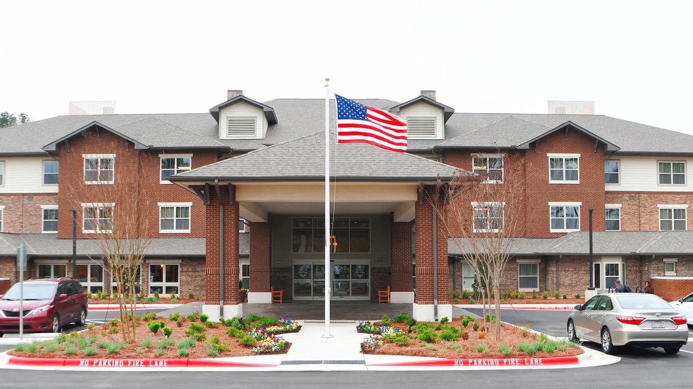 Front view of Brier Pointe Retirement Community with flag