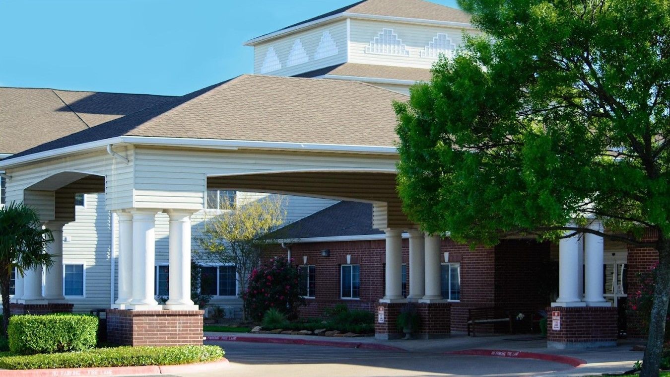 Entrance of assisted living facility with landscaping and covered driveway