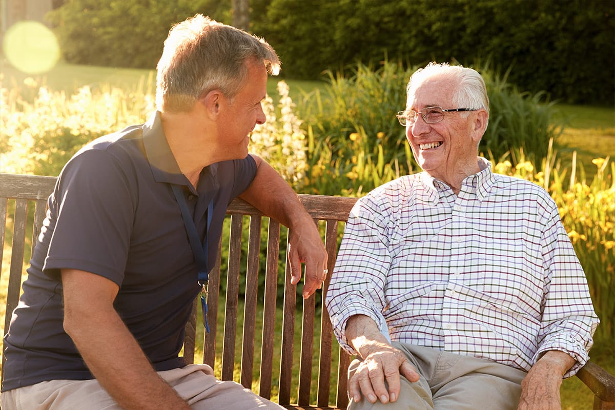 Staff member engaging with a senior resident outdoors