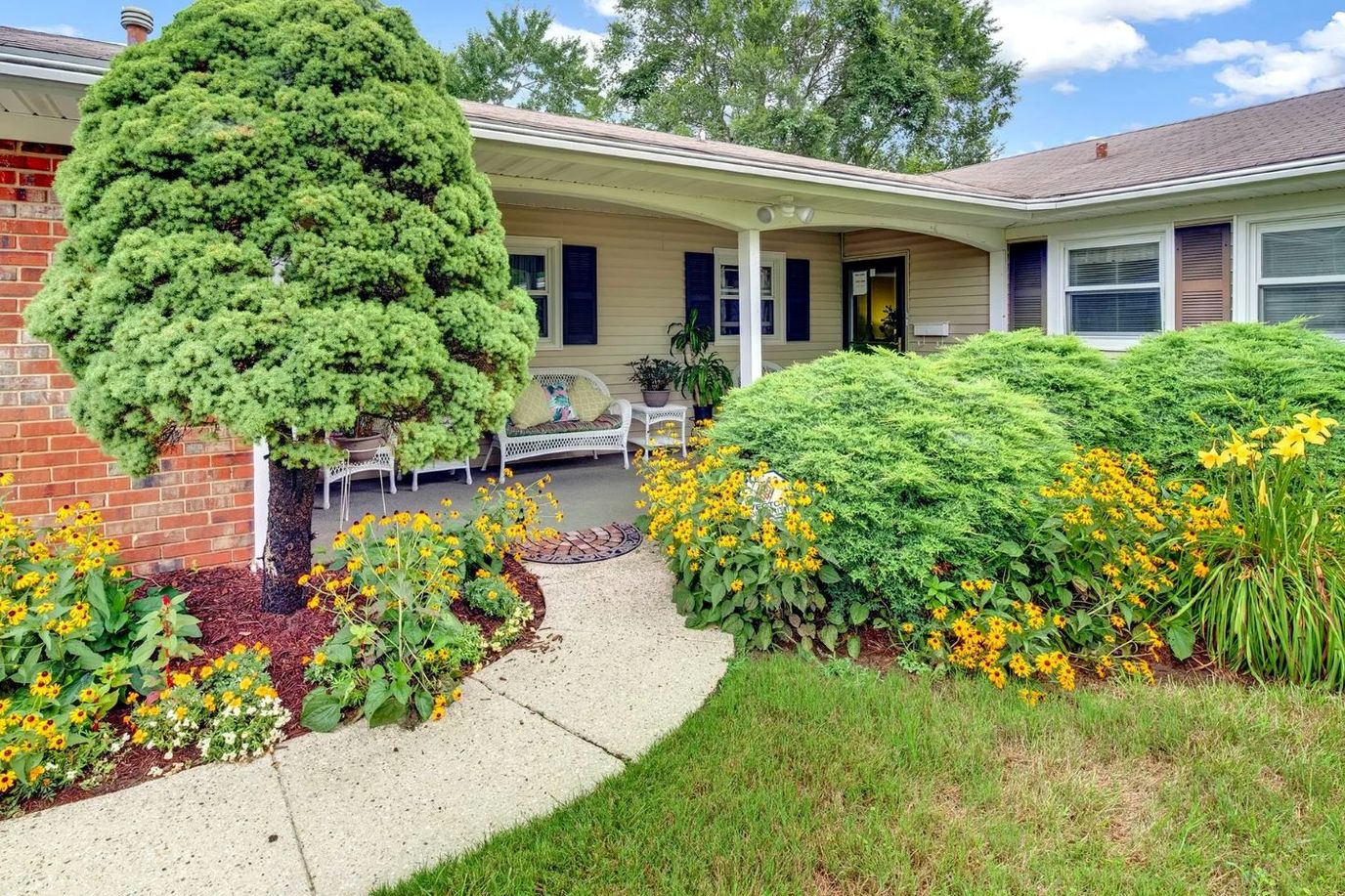 Front entrance surrounded by flowers and greenery