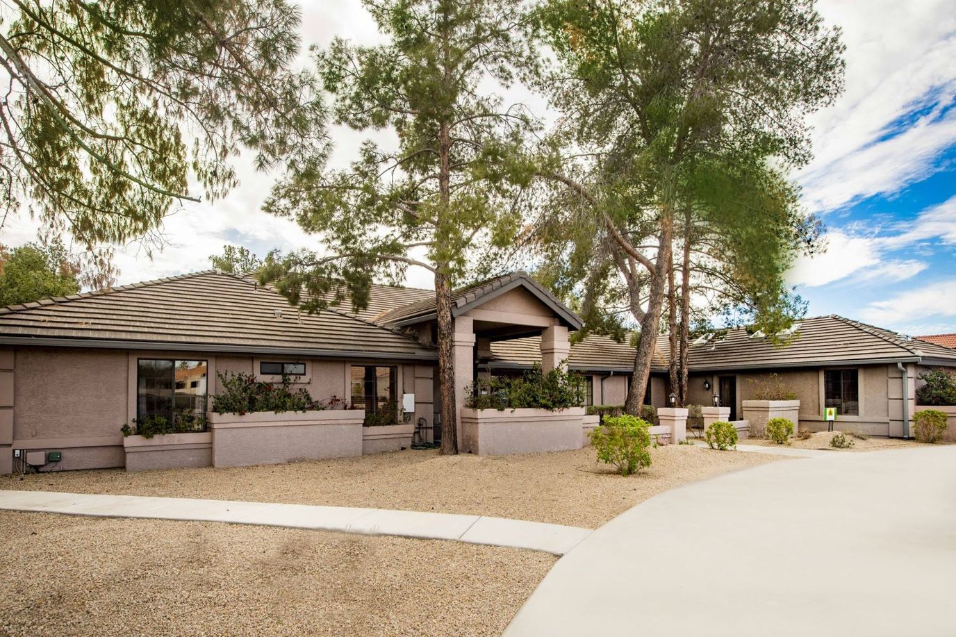 Exterior view of a senior living facility surrounded by trees