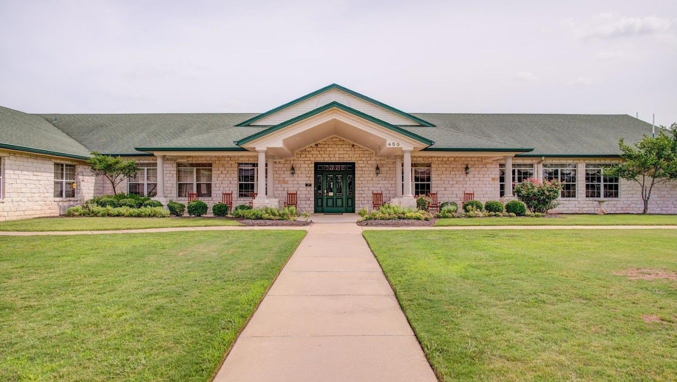 Exterior view of a senior living facility with landscaped entrance