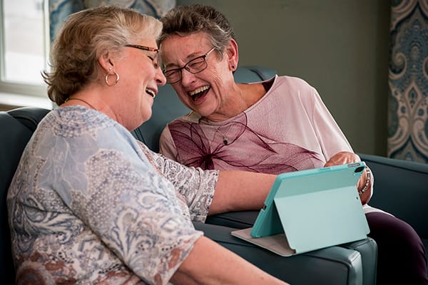 Two residents enjoying time together with a tablet