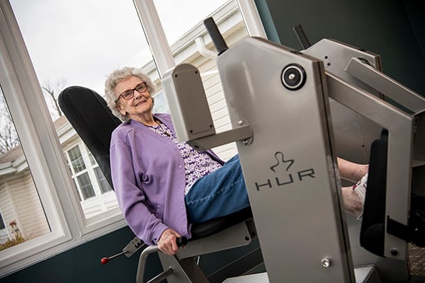 Resident using exercise equipment in a bright room