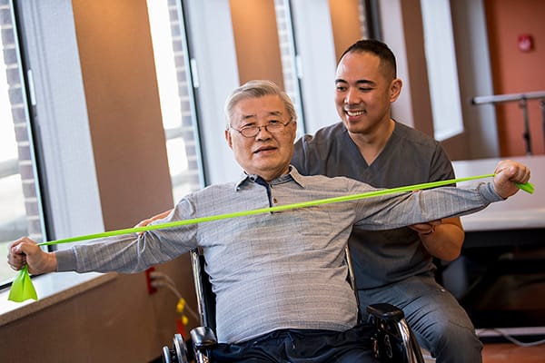 Resident engaging in physical therapy session with staff