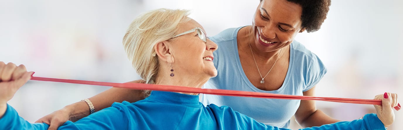 Caregiver assisting a senior with exercise