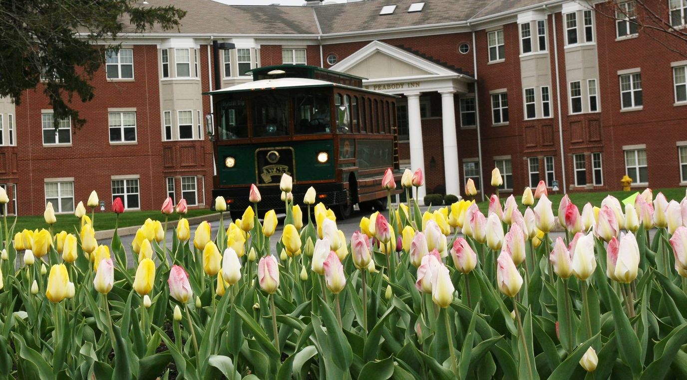Facility exterior with flowers and a trolley