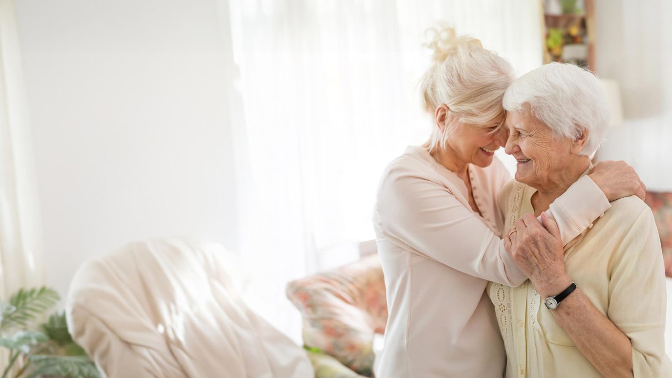 Caregiver embracing a senior resident in a bright interior