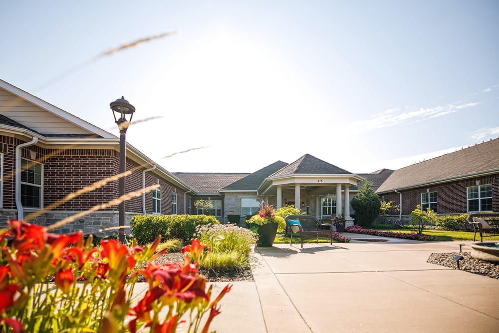 Bright exterior view of Encore Memory Care building with flowers