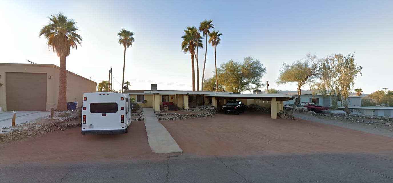 Exterior view of an assisted living facility with parking
