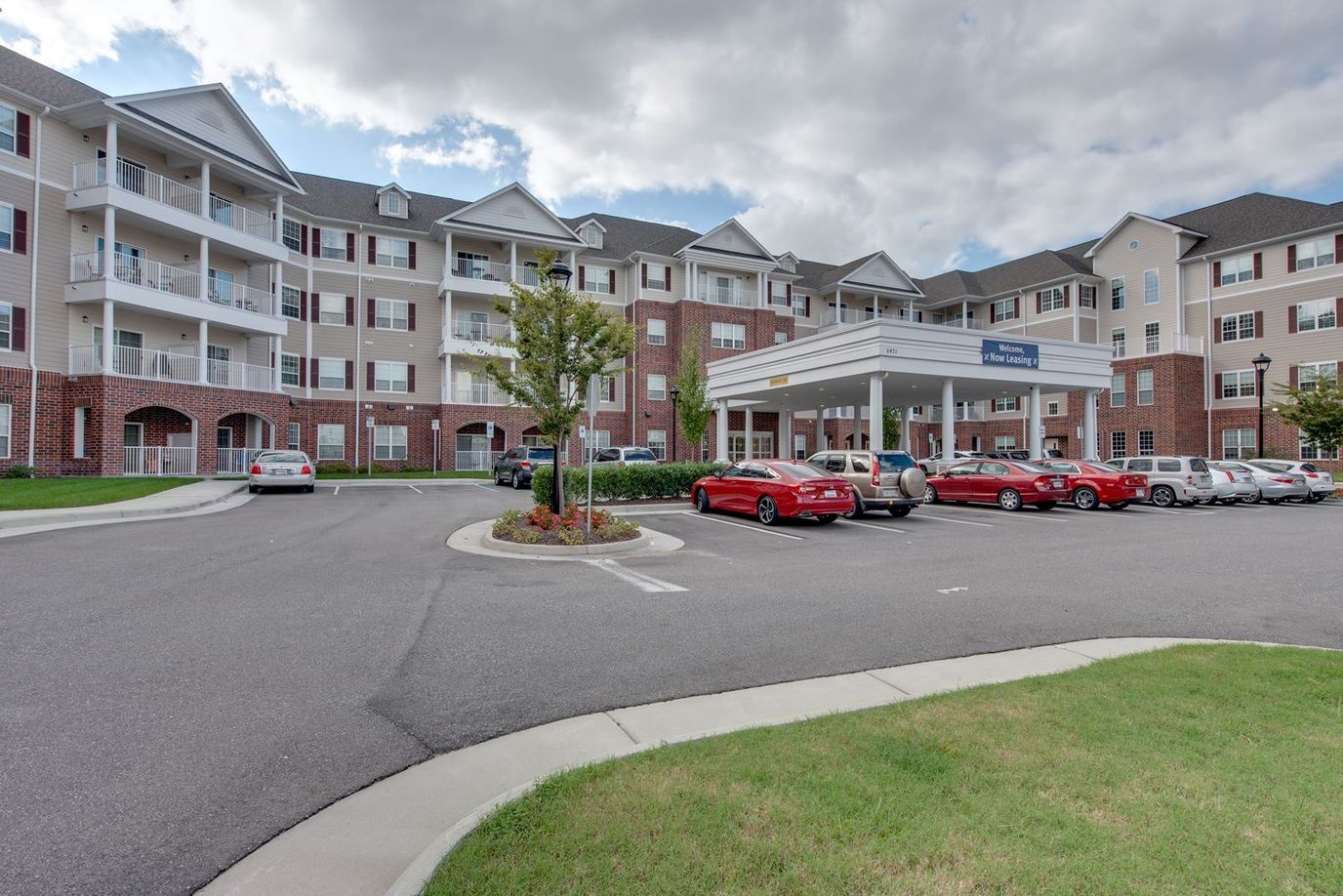 Exterior view of a senior living facility with parked cars