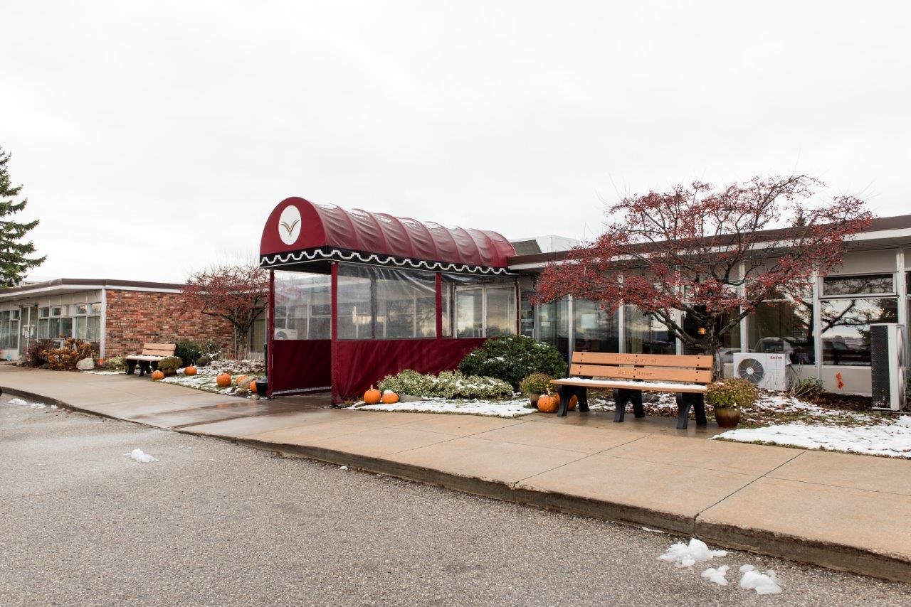 Exterior view of entrance with decorative awning and seating