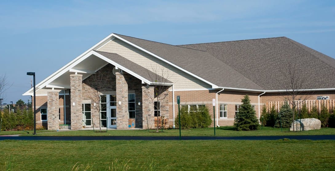 Exterior view of assisted living facility with well-maintained lawn