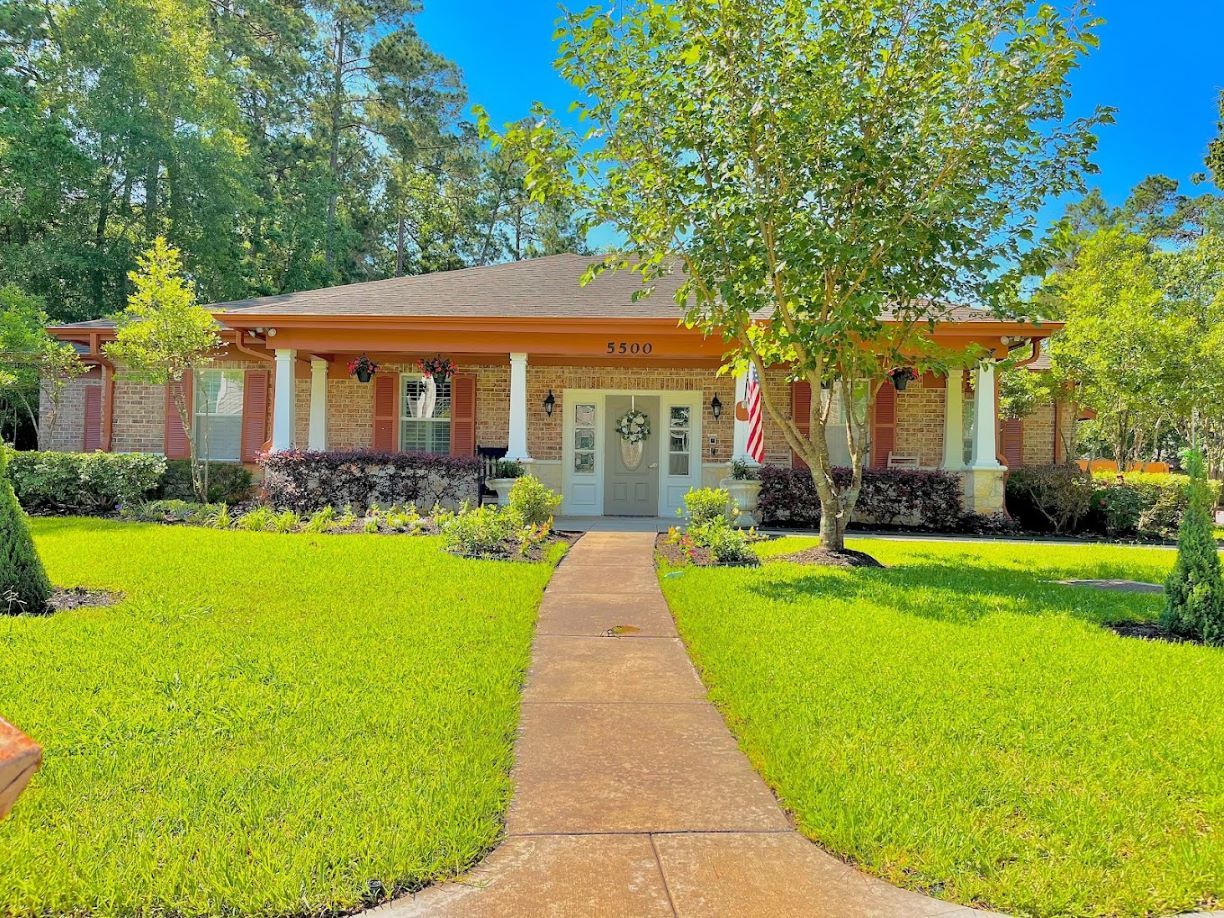 Exterior view of Bradford Grove Cottage surrounded by green lawns