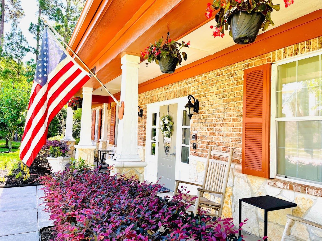 Front entrance of a senior living facility with flowers and flag