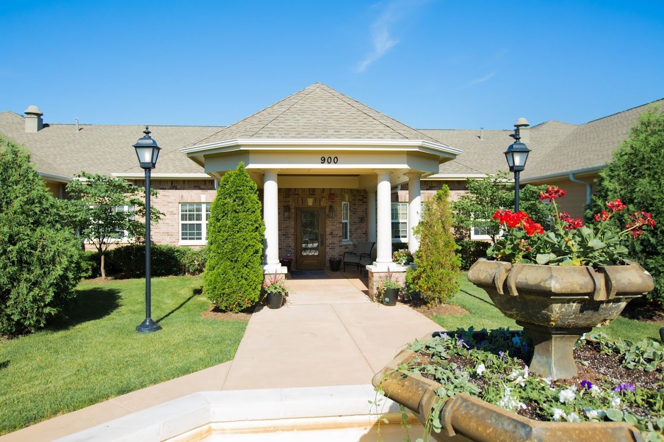 Exterior view of a senior living facility entrance with landscaping