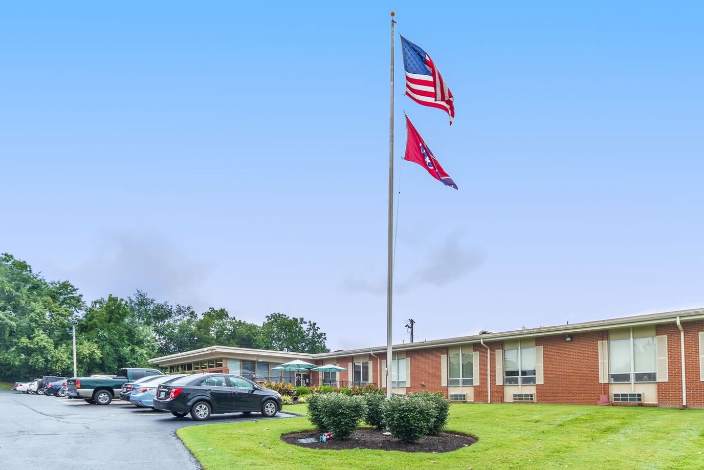 Exterior view of the facility with flags and parking