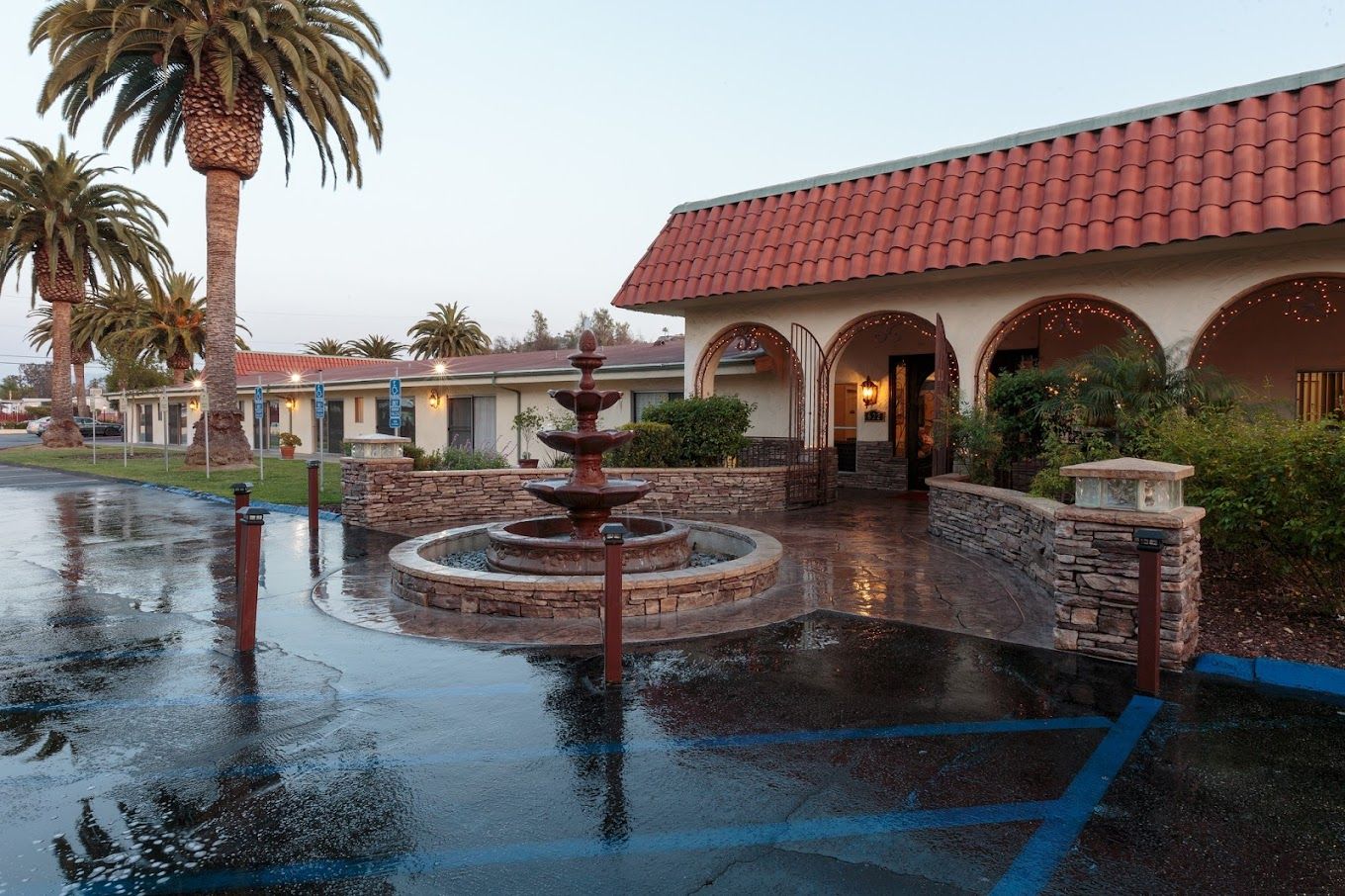 Exterior view of the facility with fountain and palm trees