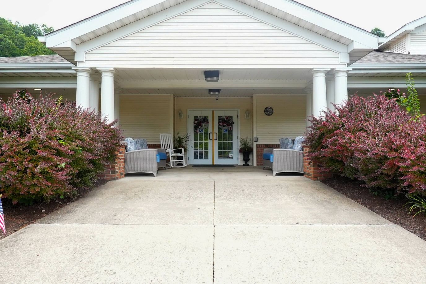 Entrance of the facility with flower beds and seating