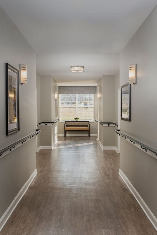 A well-lit hallway with seating and artwork